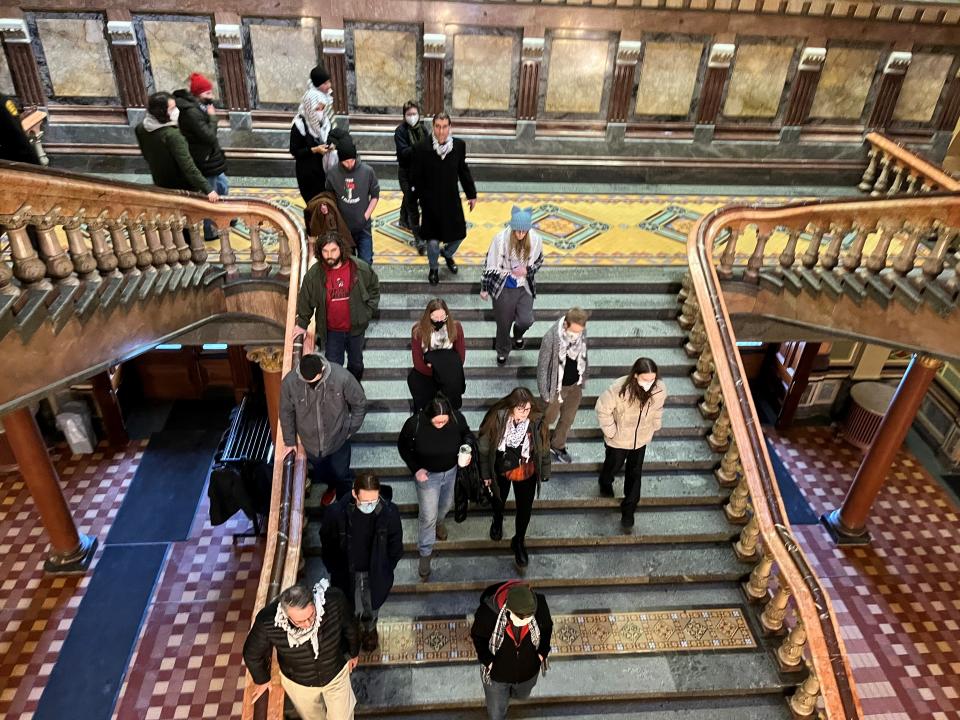 Protesters call for a ceasefire in Gaza as they march down the stairs at the Iowa State Capitol on Thursday, Jan. 18, 2024.