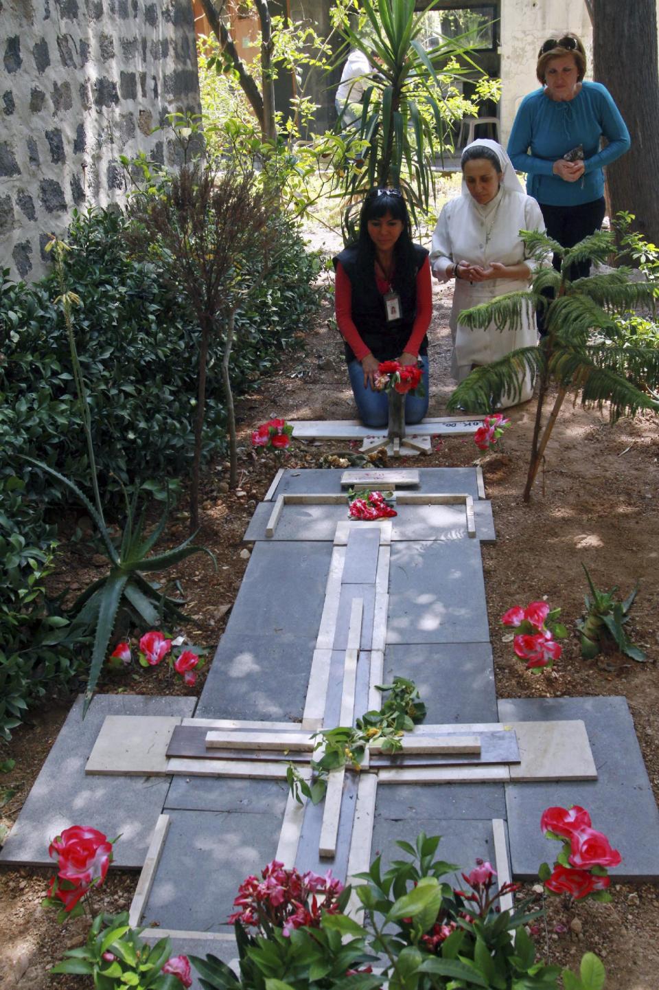 Muslim and Christian residents pay tribute to the late Father Francis Van Der Lugt, 75, who was shot to death in April in a rebel-held part of Homs, at the Monastery of Jesuit Fathers in the Old City of Homs, Syria on Saturday, May 10, 2014. Thousands of Syrians streamed into war-battered parts of the central city of Homs for the first time in nearly two years Saturday. Some citizens rushed to the area of Bustan al-Diwan, gathering to pray around the grave of Van Der Lugt who was a Jesuit, the same order as Pope Francis. (AP Photo)