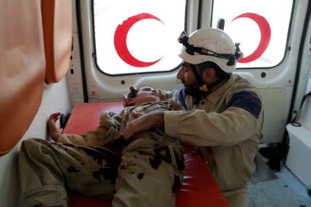 A civil defence member holds an injured boy inside an ambulance after what activists said were cluster bombs dropped by Russian air force in Maaret al-Naaman town in Idlib province, Syria October 7, 2015. REUTERS/Khalil Ashawi/File Photo