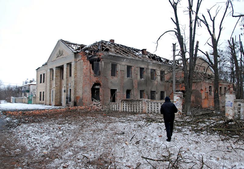 A man walks in front of a building damaged by recent shelling in Kharkiv.