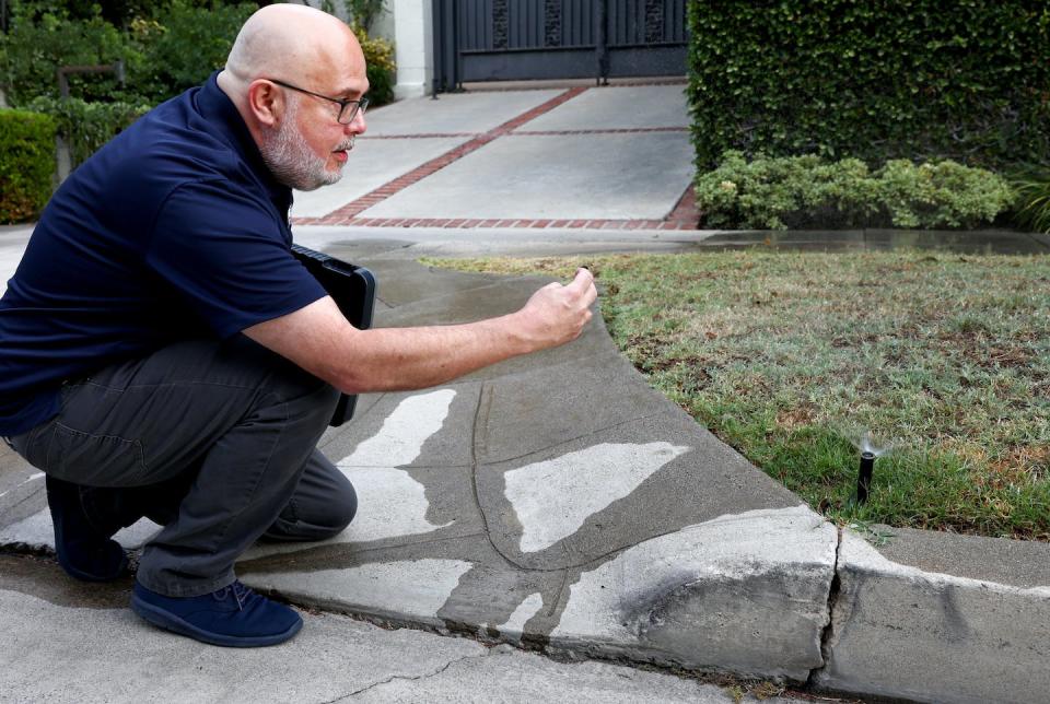 Los Angeles Department of Water and Power conservation specialist Damon Ayala inspects a sprinkler system operating in violation of a local water-saving ordinance, July 27, 2022. <a href="https://www.gettyimages.com/detail/news-photo/los-angeles-department-of-water-and-power-water-news-photo/1411282318" rel="nofollow noopener" target="_blank" data-ylk="slk:Mario Tama/Getty Images;elm:context_link;itc:0;sec:content-canvas" class="link ">Mario Tama/Getty Images</a>