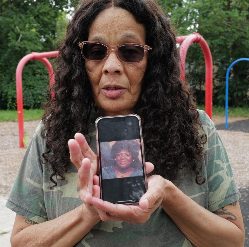 Daughter of Vernita Payne Cherryl Sasnders, holds up a photo on a cell phone of her 84 year-old mother who was killed when a tree fell through the roof of the house she had lived in for over 60 years in Lansing's Fabulous Acres neighborhood Saturday, Aug. 26, 2023.