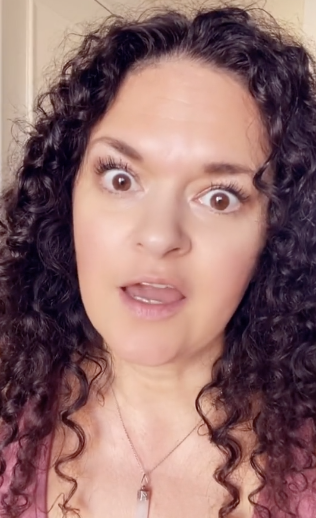 Woman with curly hair speaking in a TikTok video, with engagement stats visible: 180.4K likes, 1192 comments, 10.8K shares, and 16K saves