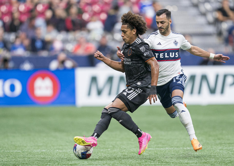Vancouver Whitecaps' Luis Martins, right, reaches for Houston Dynamo's Coco Carrasquilla while trying to slow him down during the first half of an MLS soccer match Wednesday, May 31, 2023, in Vancouver, British Columbia. (Rich Lam/The Canadian Press via AP)