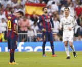 Barcelona's Lionel Messi (L) reacts as Real Madrid's Cristiano Ronaldo closes in after Real Madrid scored a third goal during their Spanish first division "Clasico" soccer match at the Santiago Bernabeu stadium in Madrid October 25, 2014. REUTERS/Juan Medina (SPAIN - Tags: SOCCER SPORT)