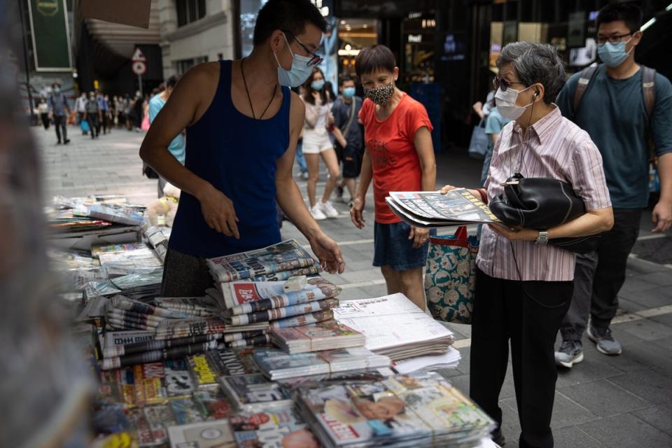 File: A woman buys newspaper at a news stand in Hong Kong, China (EPA)