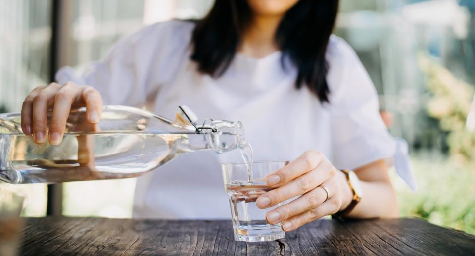 Woman pouring water into glass. People don&#39;t need eight glasses of water per day. (Getty Images)