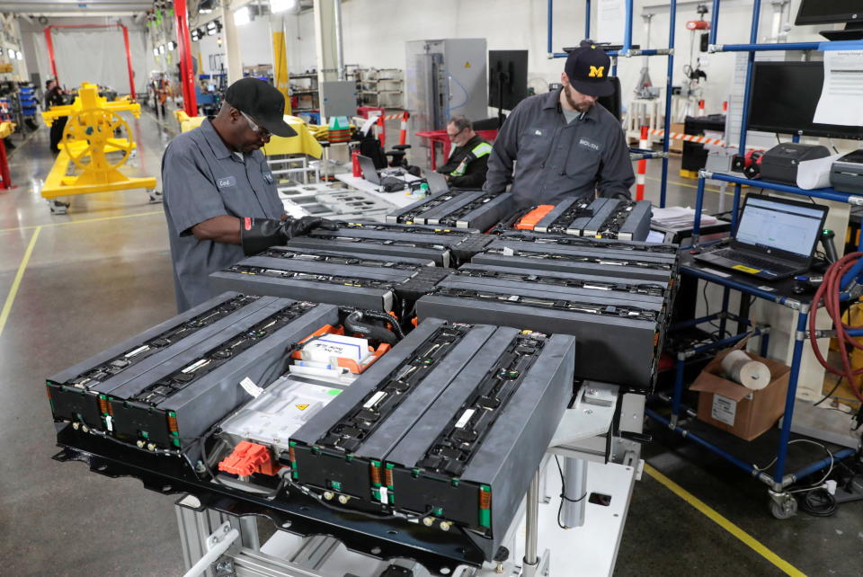 Technicians work on battery packs for electric vehicles at a manufacturing site in Livonia, Mich. 