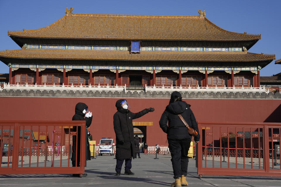 A worker directs a visitor to the Forbidden City in Beijing, Wednesday, Dec. 14, 2022. China's National Health Commission scaled down its daily COVID-19 report starting Wednesday in response to a sharp decline in PCR testing since the government eased antivirus measures after daily cases hit record highs. (AP Photo/Ng Han Guan)