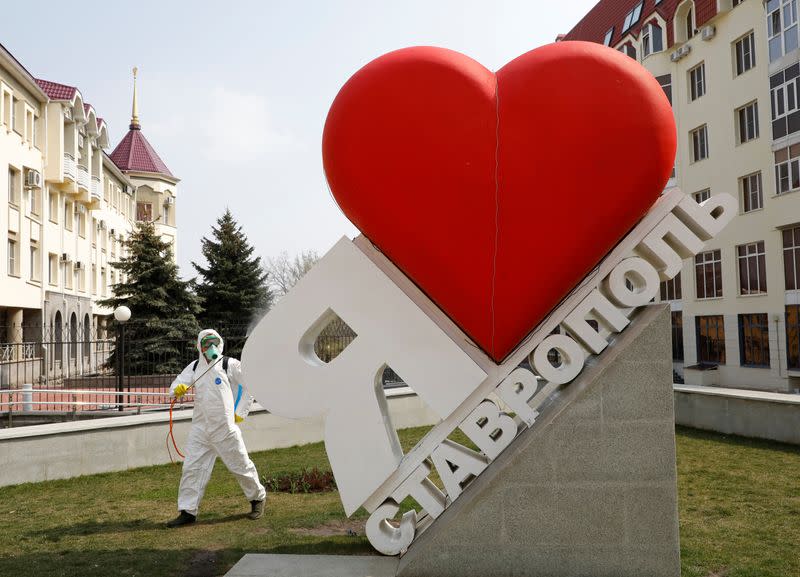 A specialist sprays disinfectant on a sign reading "I love Stavropol" in Stavropol