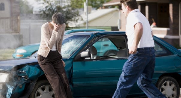 man helping a woman after a car accident