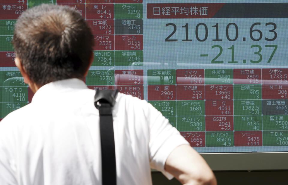 A man looks at an electronic stock board showing Japan's Nikkei 225 index at a securities firm in Tokyo Friday, June 14, 2019. Asian shares were mixed Friday as investors weighed a variety of factors, including suspected attacks on two oil tankers in the strategic Strait of Hormuz and lingering worries about trade conflict between the U.S. and China. (AP Photo/Eugene Hoshiko)