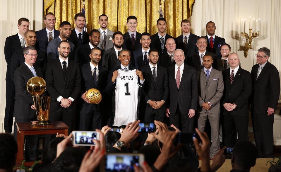 U.S. President Barack Obama poses for a team photo as he welcomes the 2014 NBA Champion San Antonio Spurs to the East Room of the White House in Washington, January 12, 2015. REUTERS/Larry Downing (UNITED STATES - Tags: POLITICS SPORT BASKETBALL)