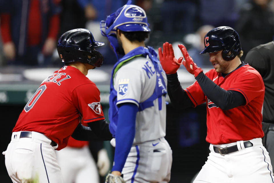 Cleveland Guardians' Owen Miller, right, celebrates with Andres Gimenez, left, after hitting a two-run home run as Kansas City Royals catcher MJ Melendez looks on during the fifth inning of a baseball game, Tuesday, Oct. 4, 2022, in Cleveland. (AP Photo/Ron Schwane)