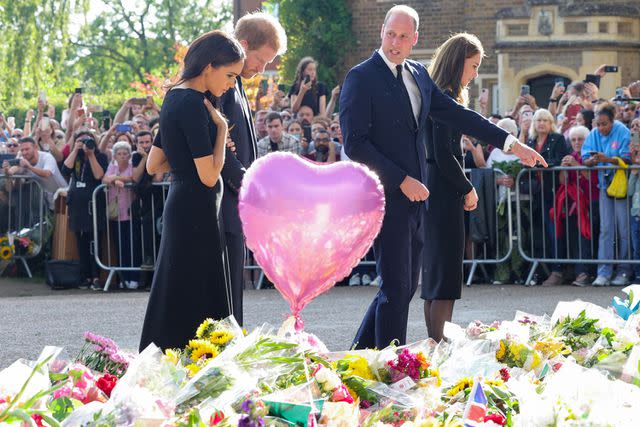 <p>Chris Jackson - WPA Pool/Getty</p> Harry and Meghan viewing tributes to Queen Elizabeth last year, with Prince William and Kate Middleton