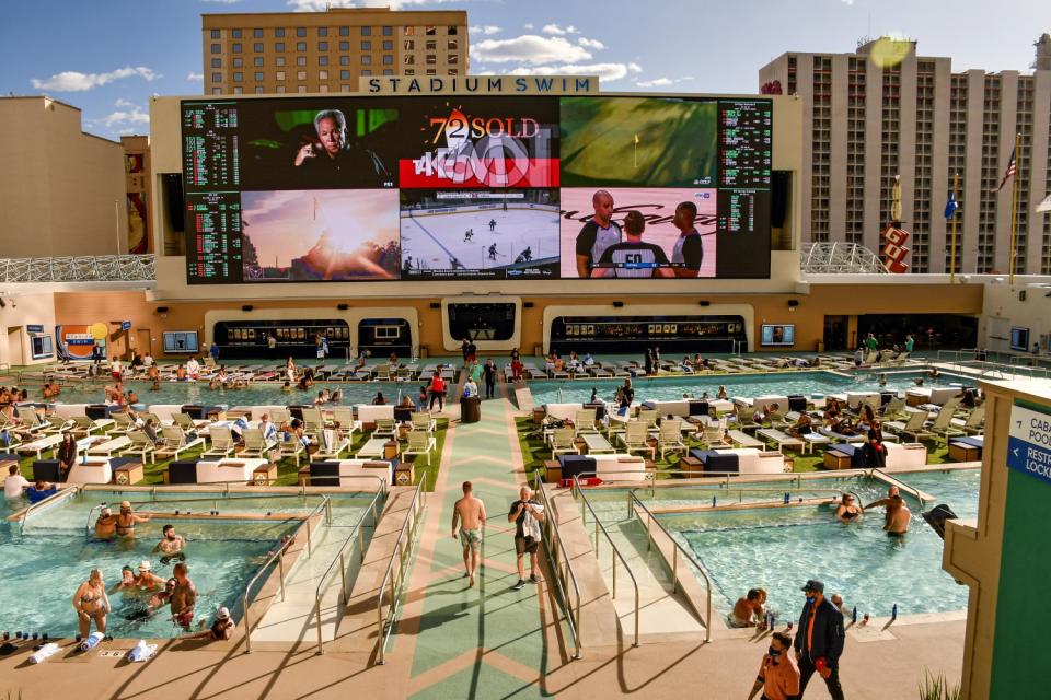 Multiple pools and large video screens at the Circa hotel and casino Stadium Swim area