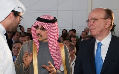 Saudi billionaire Prince Alwaleed bin Talal, centre, talks to his assistant, as Rupert Murdoch watches at the 2010 Abu Dhabi Media Summit - Credit:  REUTERS/Handout