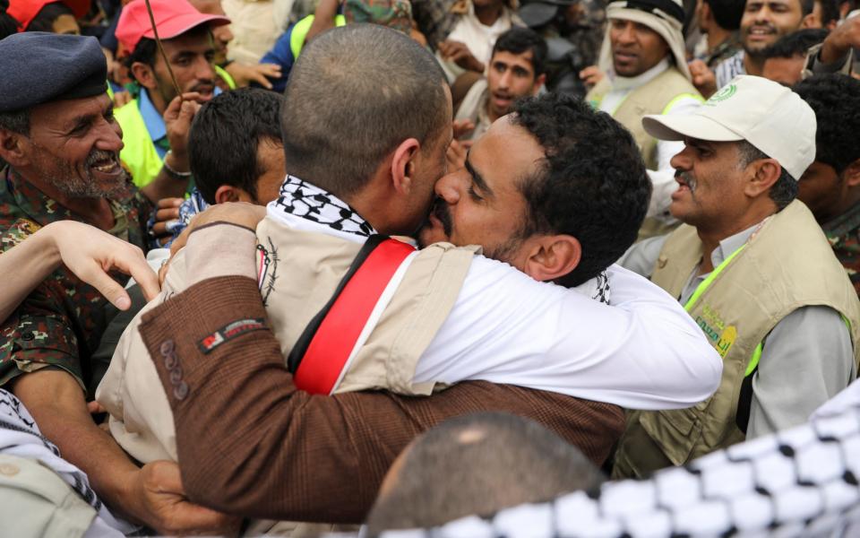 Freed prisoners hug their relatives at Sanaa airport - REUTERS