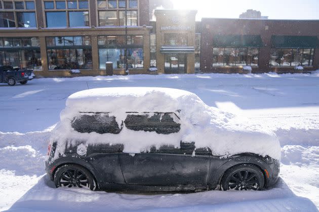 A snowed-in car is left parked in downtown Minneapolis on Thursday.