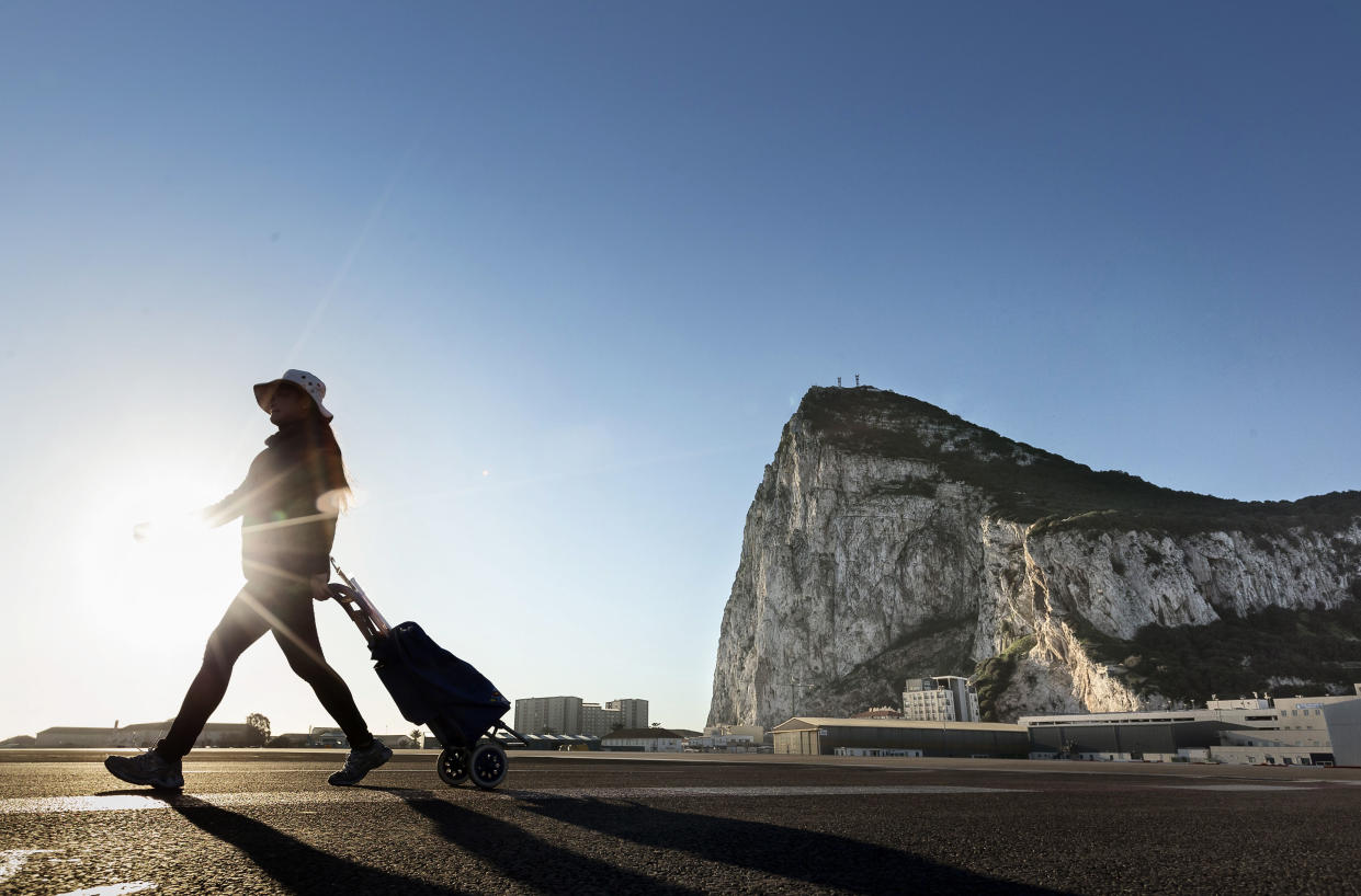 A woman walks on the Spanish side of the border between Spain and the British overseas territory of Gibraltar. (AP Photo/Daniel Ochoa de Olza, File)