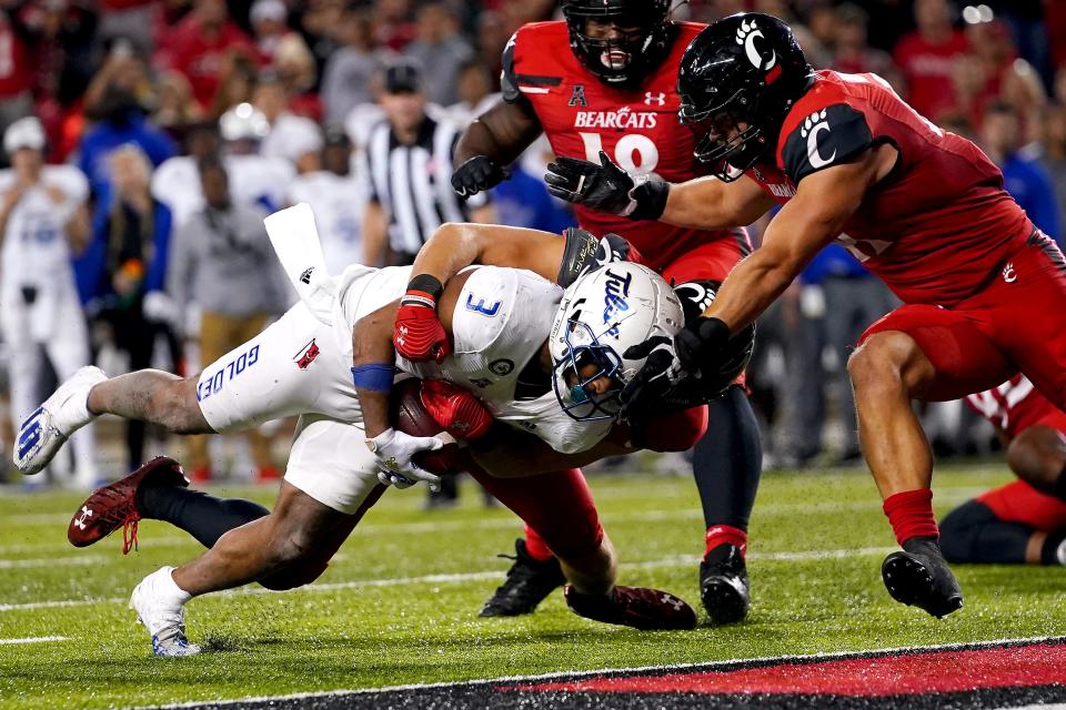 University of Cincinnati linebacker Wilson Huber (2), tackling Tulsa running back Shamari Brooks (3) in 2021, considers this year's matchup with the Golden Hurricanes where the road starts to the Bearcats' next AAC championship.