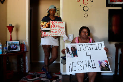 Audrey Tate, left, and Beverly Wray, right, hold signs for their late niece on Thursday, Sept. 1, 2022