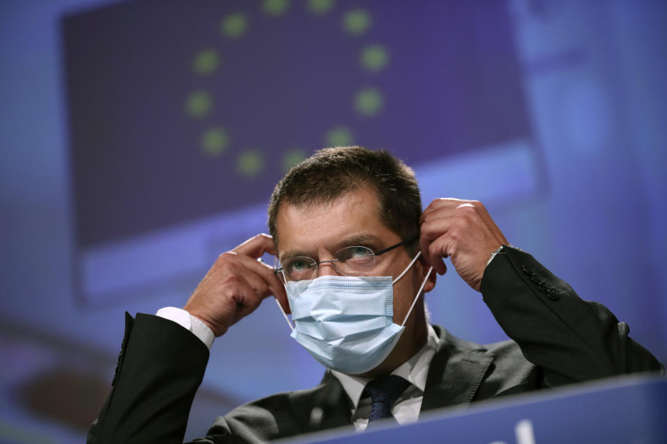 European Commissioner for Crisis Management Janez Lenarcic puts on his face mask at the end of an online media conference at the European Commission headquarters in Brussels, Tuesday, Sept. 22, 2020. Lenarcic said the Commission has increased its stockpile of protective medical equipment and supplies in order to support member states if the health situation deteriorates further in the winter. (AP Photo/Francisco Seco, Pool)