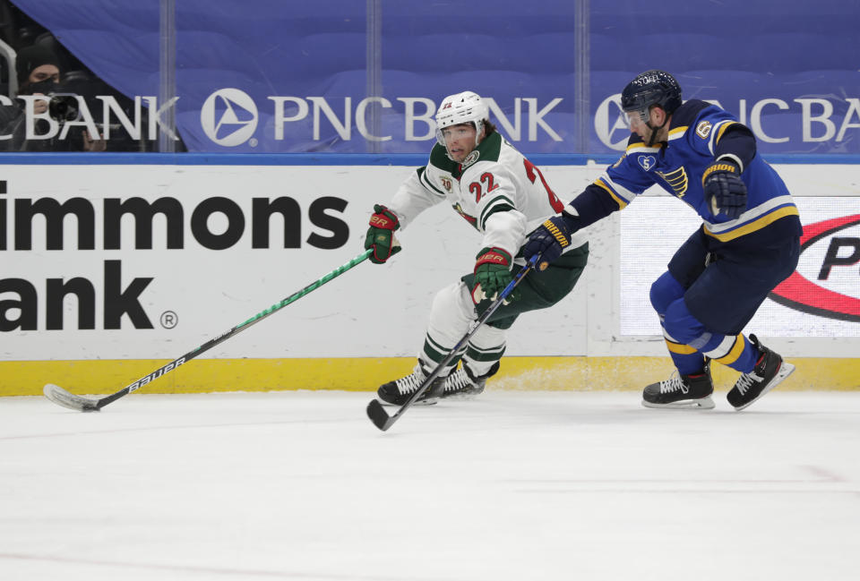 Minnesota Wild's Kevin Fiala (22) fights off St. Louis Blues' Marco Scandella (6) as he skates with the puck in the first period of an NHL hockey game, Wednesday, May 12, 2021 in St. Louis. (AP Photo/Tom Gannam)