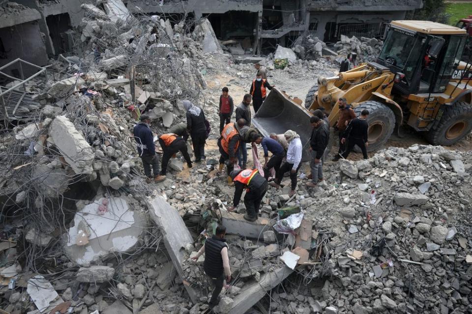 Palestinians search for survivors after an Israeli airstrike on a residential building of the Yaghi family in Deir al Balah, Gaza Strip, Friday, Feb. 23, 2024.