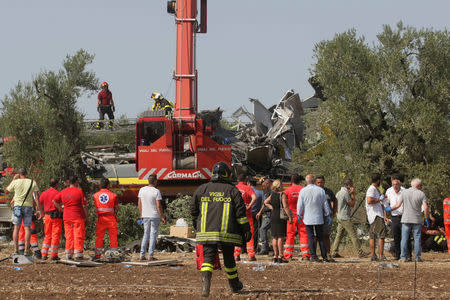 Firefighters work at the site where two passenger trains collided in the middle of an olive grove in the southern village of Corato, near Bari, Italy July 12, 2016. REUTERS/Stringer