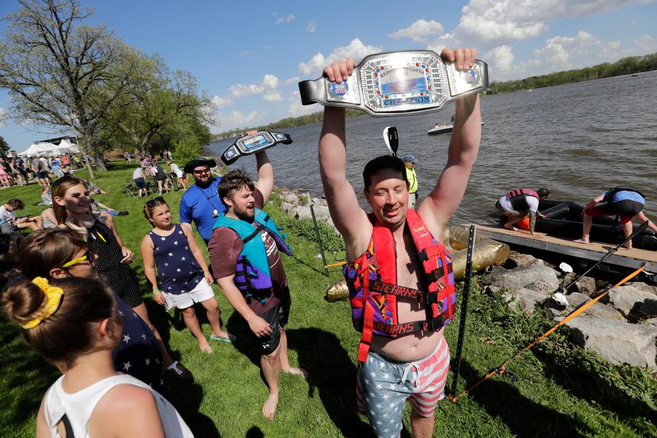 Cody Weisnicht, left, and Adam Mueller raise their champion belts in victory after winning the Redneck Regatta during Celebrate De Pere in 2019. New champions of the homemade cardboard boat race will be crowned this weekend.