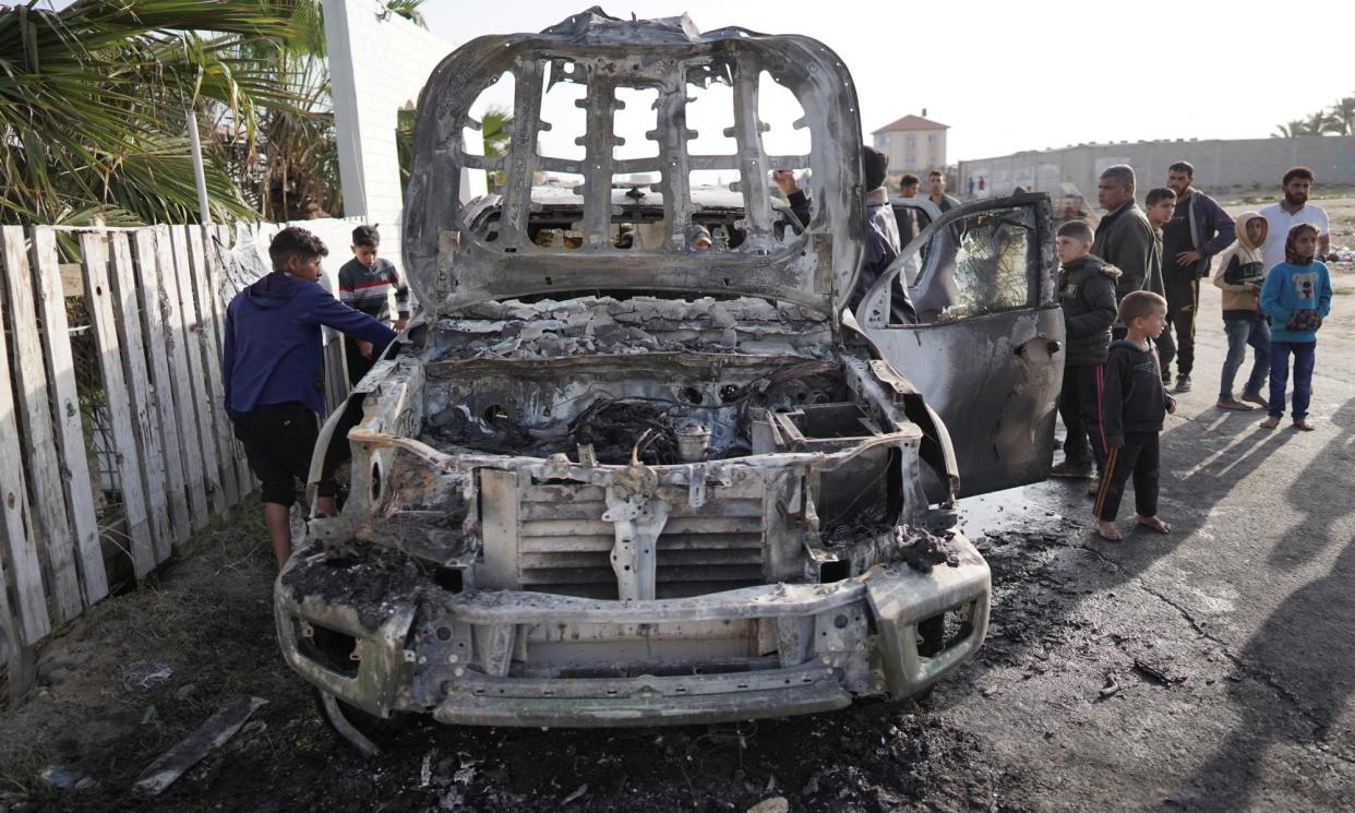 <span>People gather around one of the cars of the aid group World Central Kitchen that was hit by an Israeli strike in Deir al-Balah, Gaza.</span><span>Photograph: AFP/Getty Images</span>