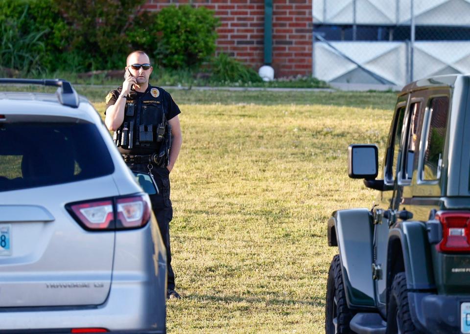 Law enforcement stand outside of Henryetta High School on Monday, May 1, 2023, as people arrive for a vigil after Okmulgee County Sheriff reported seven people dead after a search for two missing teenage girls.