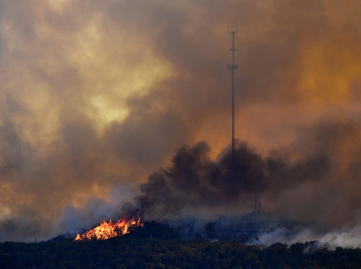 Flames consume the area near a radio tower during Friday’s Hill Top Fire south of Abilene.