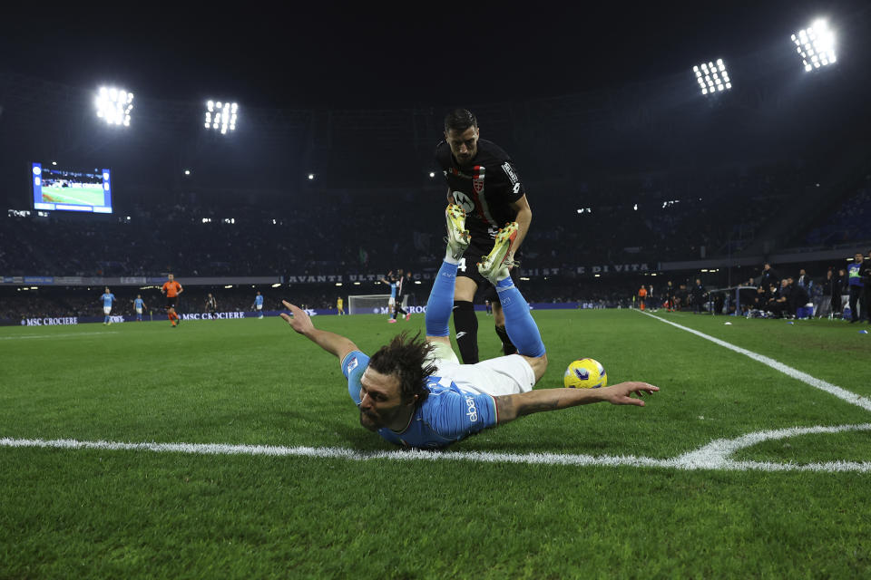 Mario Rui, en el césped, de Napoli, y Patrick Ciurria, de Monza, disputan un balón durante el partido de fútbol de la Serie A de Italia entre Napoli y Monza en el estadio Diego Armando Maradona, en Nápoles, Italia, el viernes 29 de diciembre de 2023. (Alessandro Garofolo/LaPresse vía AP)