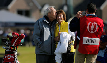 Arnold Palmer kisses his wife Kathleen Gawthrop as they pose for a photograph on the first green during the Champion Golfers' Challenge tournament ahead of the British Open golf championship on the Old Course in St. Andrews, Scotland. REUTERS/Paul Childs