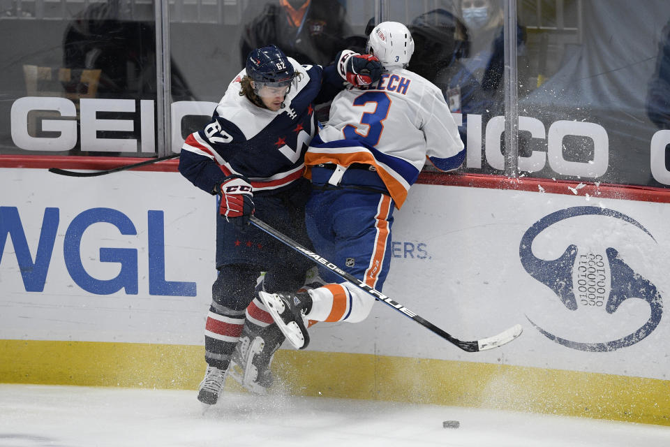 Washington Capitals left wing Carl Hagelin (62) and New York Islanders defenseman Adam Pelech (3) collide along the boards during the second period of an NHL hockey game Tuesday, Jan. 26, 2021, in Washington. (AP Photo/Nick Wass)