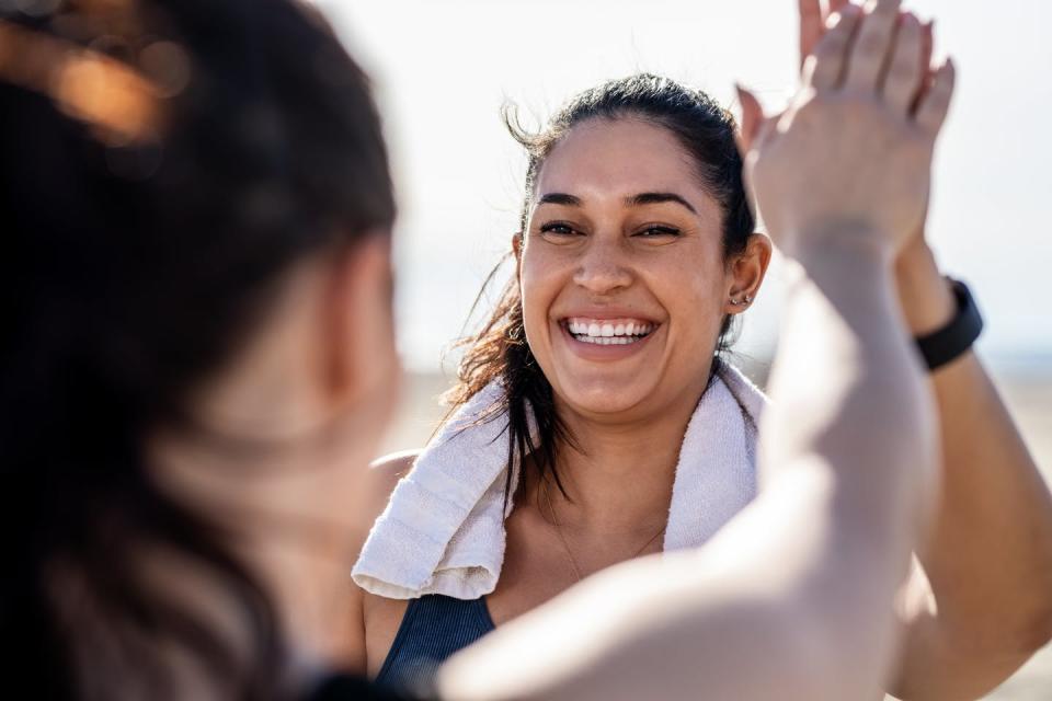 Person smiling and high-fiving friend while exercising