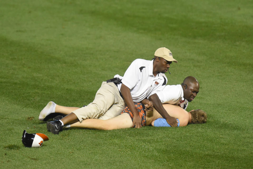 Security guards restrain a fan who ran out on the field during a baseball game between the Baltimore Orioles and the Toronto Blue Jays at Oriole Park at Camden Yards on September 28, 2015 in Baltimore, Maryland. The Blue Jays won 4-3. (Photo by Mitchell Layton/Getty Images)