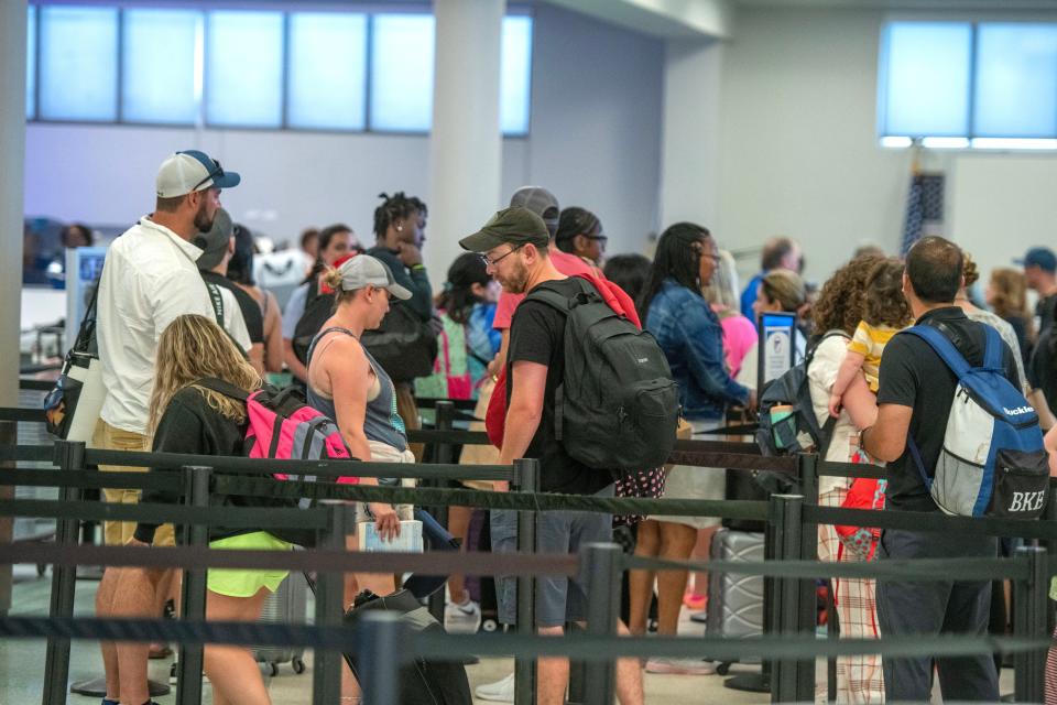 Passengers at Pensacola International Airport go through security checks Sunday, July 2, 2023.
