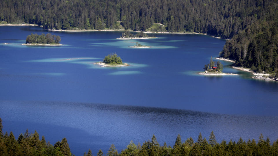 The sun is shining over the deep blue lake 'Eibsee' at the highest German mountain 'Zugspitze' (2962 meters) near Garmisch-Partenkirchen, Germany, Friday, May 29, 2020. Germany's tourism is slowly restarting as the government is easing the coronavirus lockdown rules. The mountain railway will reopen tomorrow after the lockdown because of the coronavirus crisis. (AP Photo/Matthias Schrader)