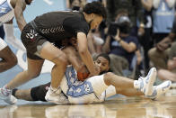 Brown guard Dan Friday, top, reaches for the ball as North Carolina guard R.J. Davis (4) goes to the floor during the second half of an NCAA college basketball game in Chapel Hill, N.C., Friday, Nov. 12, 2021. (AP Photo/Gerry Broome)