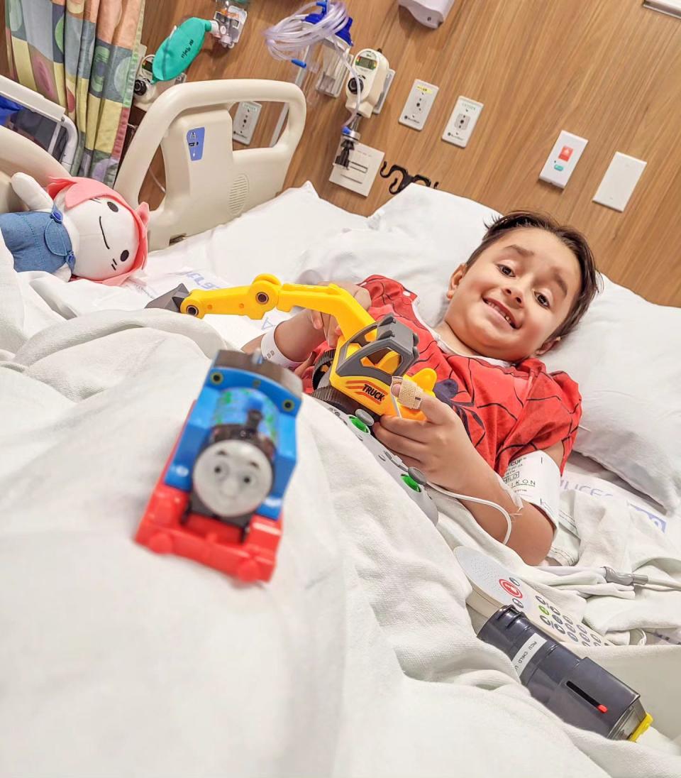Oliver Aleman, 8, recovers in his hospital bed after having a heart transplant. Oliver's favorite toys are Thomas the Tank Engine and construction toys.