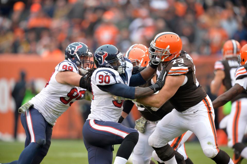 Houston Texans defensive end J.J. Watt (99) and outside linebacker Jadeveon Clowney (90) rush Cleveland Browns tackle Joe Thomas in the third quarter of an NFL football game Sunday, Nov. 16, 2014, in Cleveland. (AP Photo/David Richard)