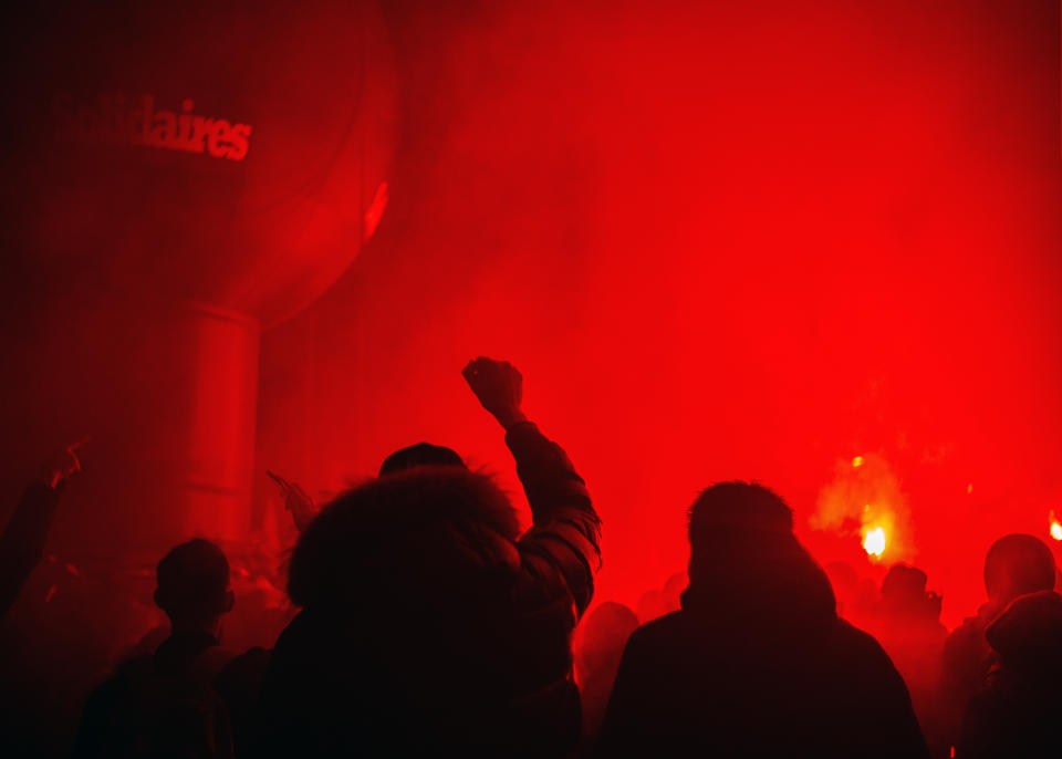 People march among flares during a demonstration in Paris, Thursday, Dec. 5, 2019. The Eiffel Tower shut down, France's high-speed trains stood still and tens of thousands of people marched through Paris and other cities Thursday, in a massive and sometimes chaotic outpouring of anger at the government's plan to overhaul the retirement system. (AP Photo/Rafael Yaghobzadeh)