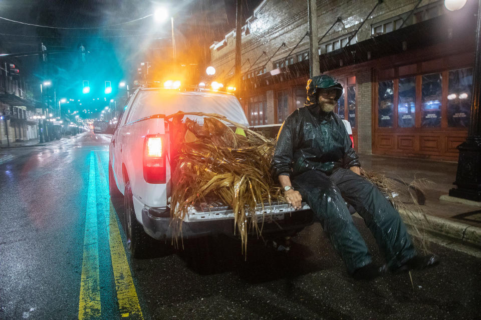 <p>Lew Hendrix collects palm branches blown down by the outer bands of Hurricane Ian in the Ybor City neighborhood of Tampa on Sept. 28, as rains drench the city.</p>