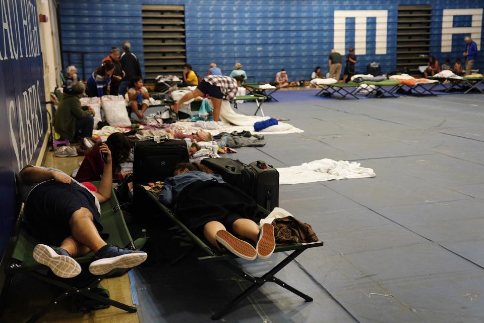 Residents and tourists seek shelter at Maui High School, in Kahului. 