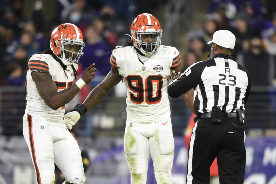 Cleveland Browns defensive end Takkarist McKinley, left, and defensive end Jadeveon Clowney talk to referee Jerome Boger (23) after a play against the Baltimore Ravens during the second half of an NFL football game, Sunday, Nov. 28, 2021, in Baltimore. (AP Photo/Gail Burton)