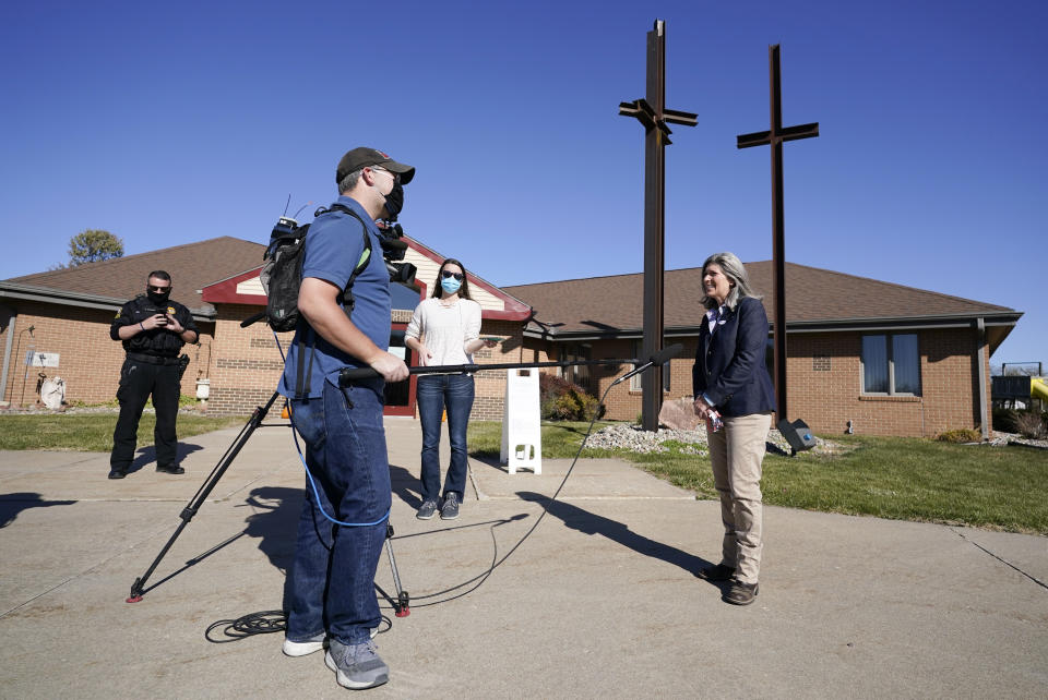 Republican Senate candidate Sen. Joni Ernst, right, talks to a reporter after casting her ballot at Red Oak First Christian Church Tuesday, Nov. 3, 2020, in Red Oak, Iowa. (AP Photo/Charlie Neibergall)