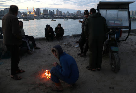 People rest as they wait for fishermen to come back with their catch, after Israel expanded fishing zone for Palestinians, at the seaport of Gaza City April 2, 2019. REUTERS/Suhaib Salem